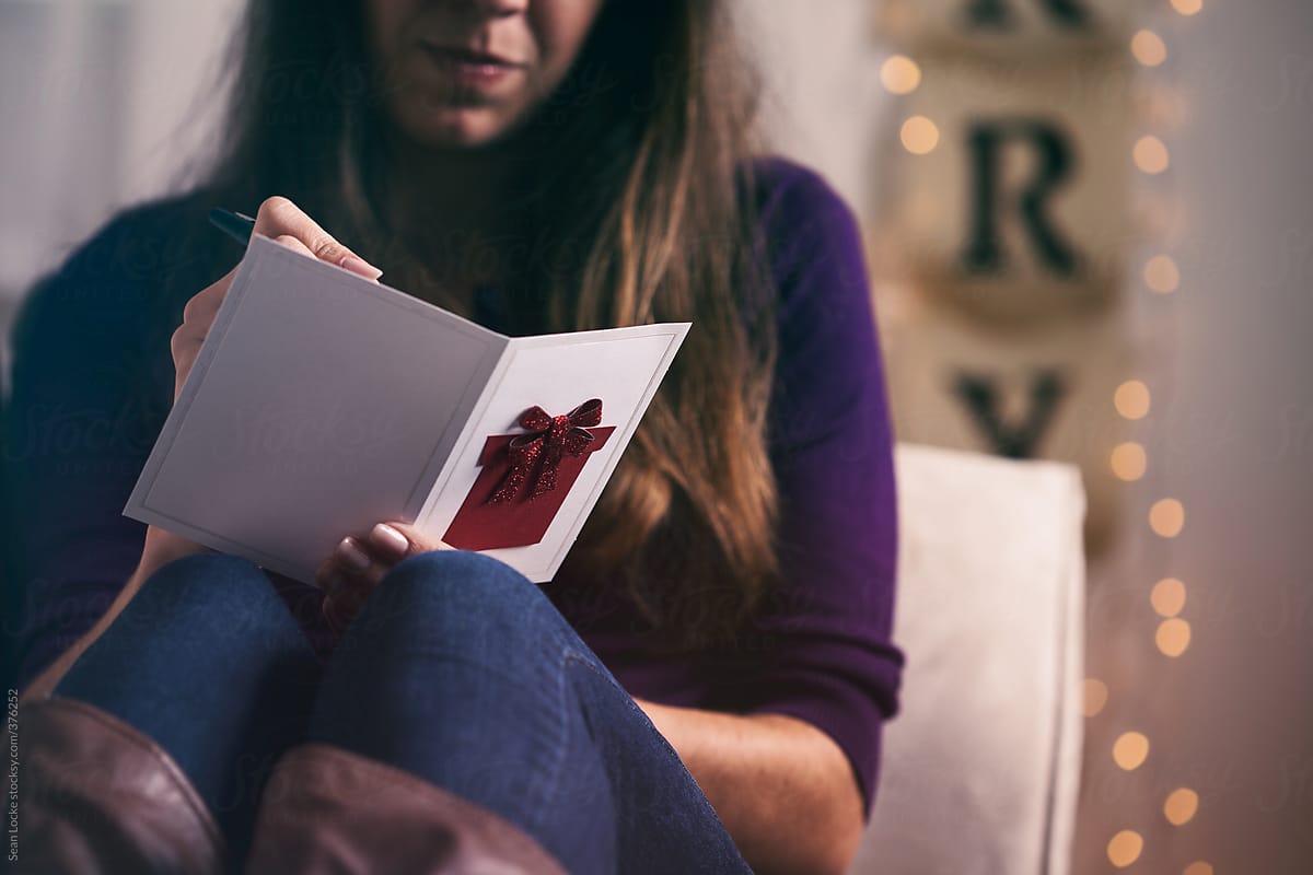 Christmas: Woman Sits On Couch Writing Greeting Card