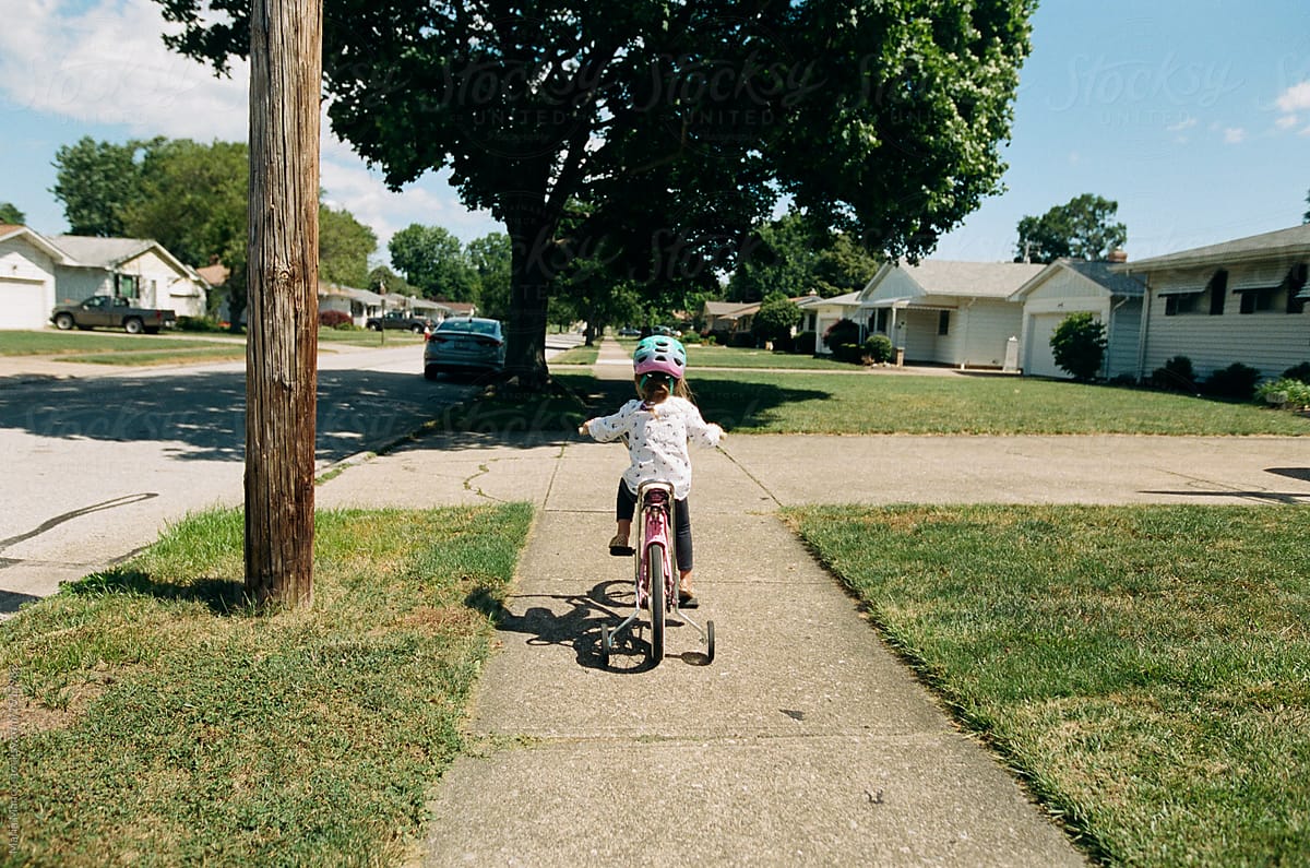 Girl on bike with training wheels