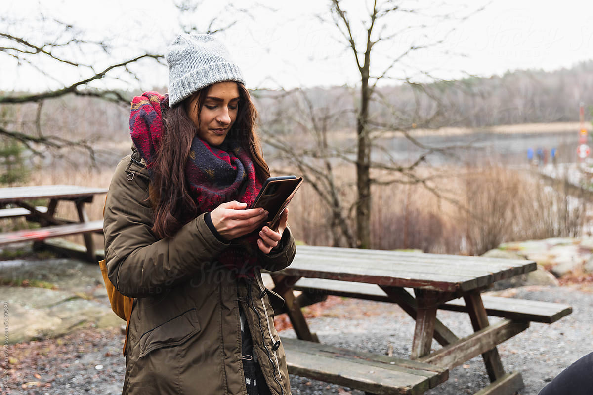 Young woman outdoors checking smartphone