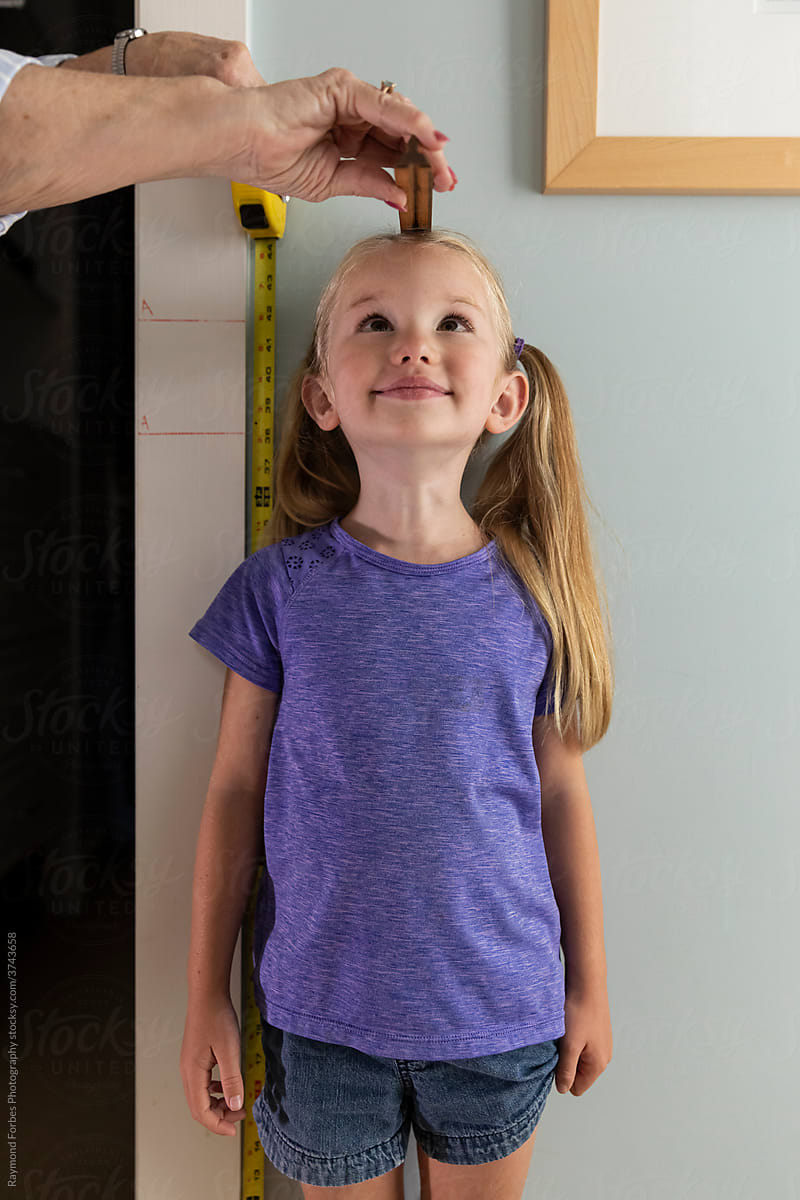 Adorable Young Girl Measuring her height