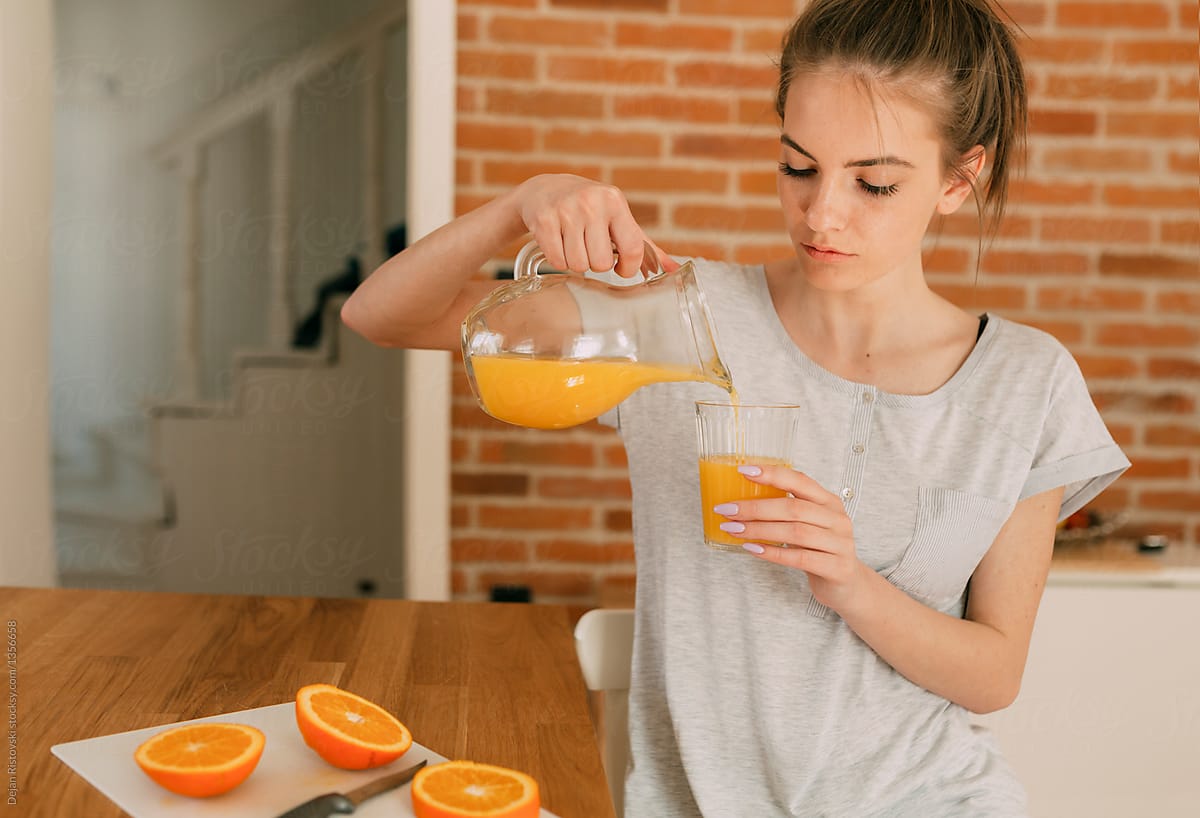 Girl taking an orange juice for breakfast.