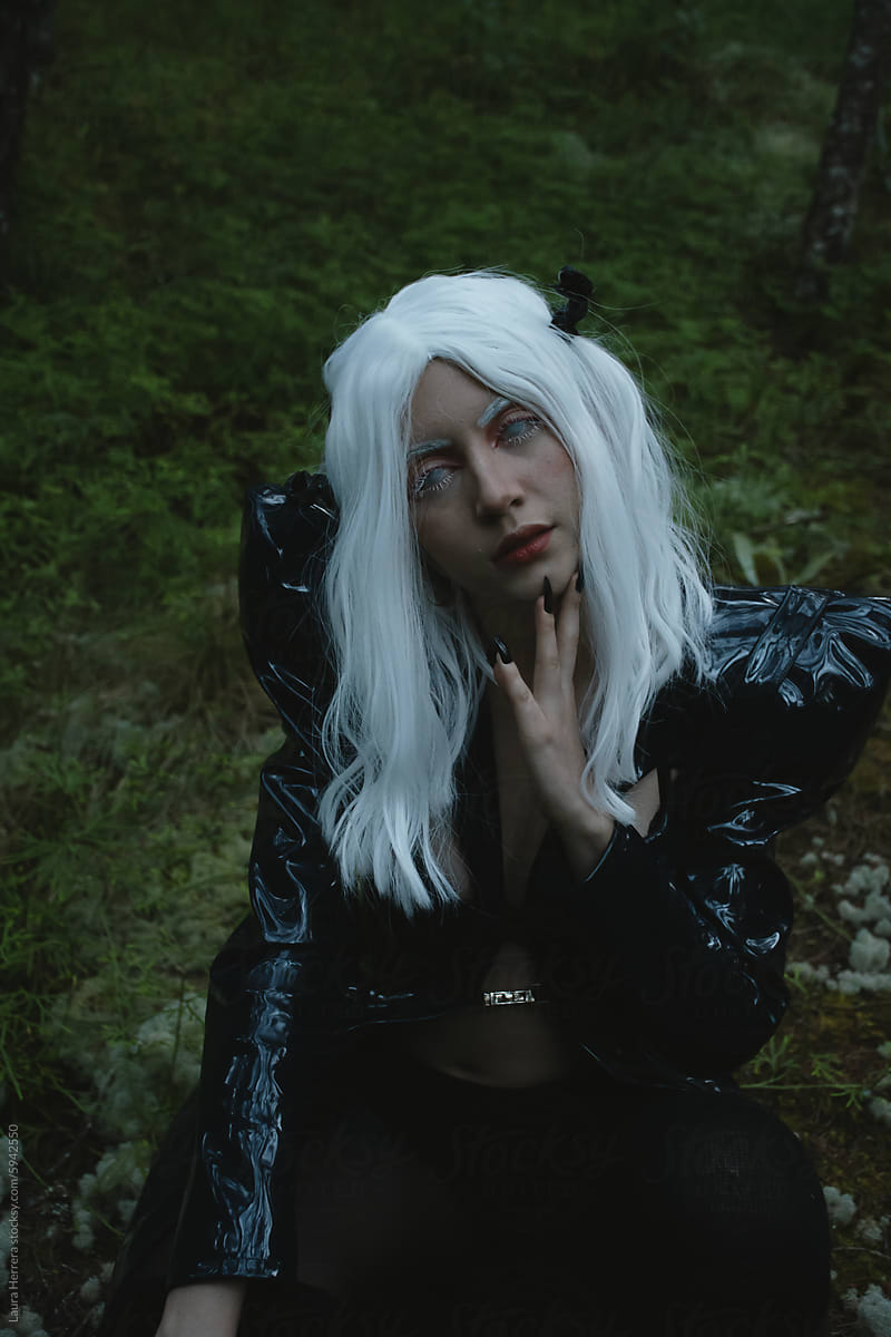 Futuristic Woman  in Black Costume  with White Wig in a Forest  Sunset