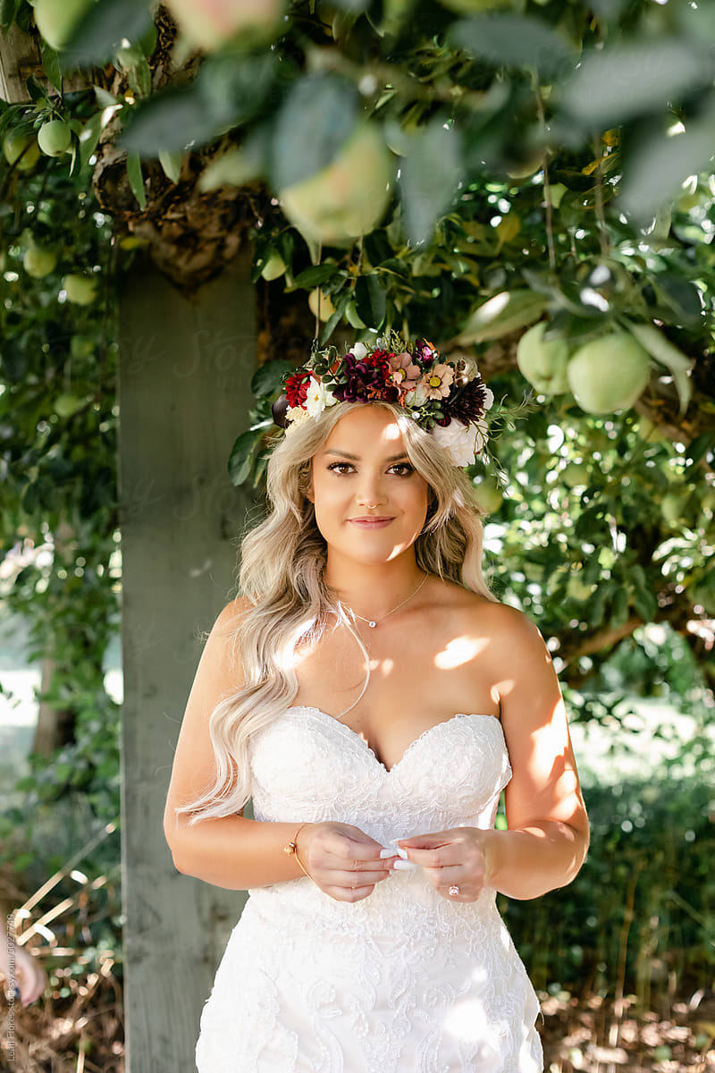 A Beautiful Blond Bride Standing in an Apple Orchard