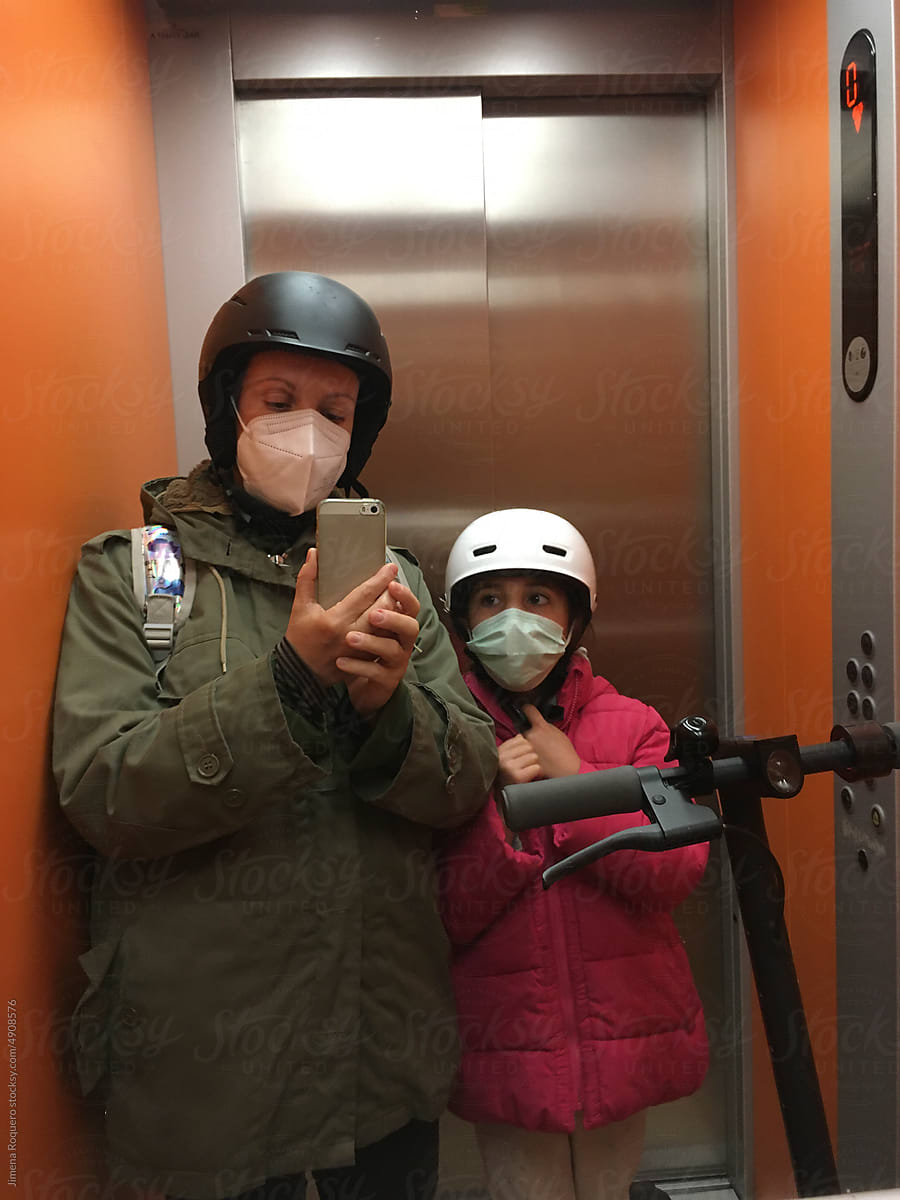 UGC mother and child winter elevator selfie with helmets and scooter