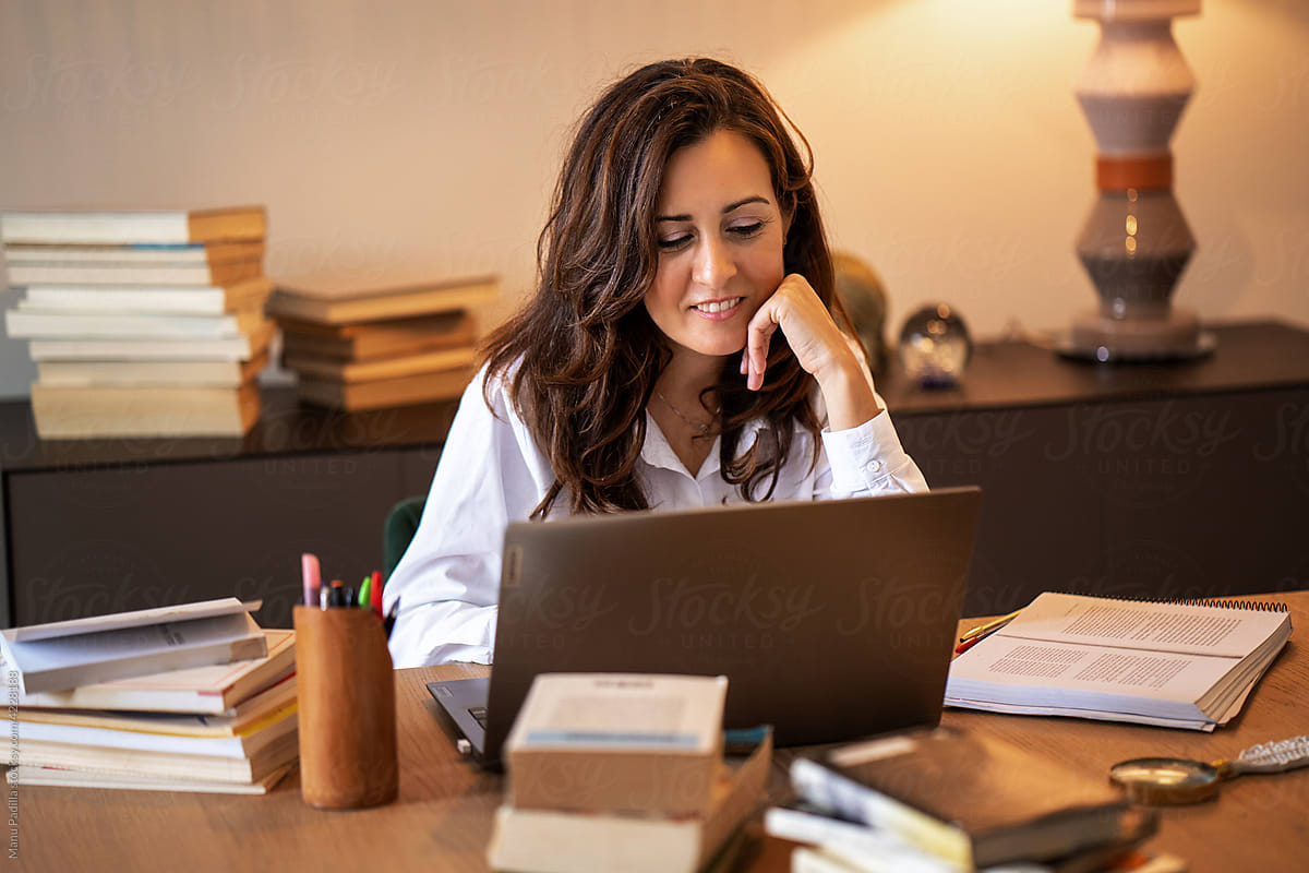 Positive Hispanic woman working on laptop