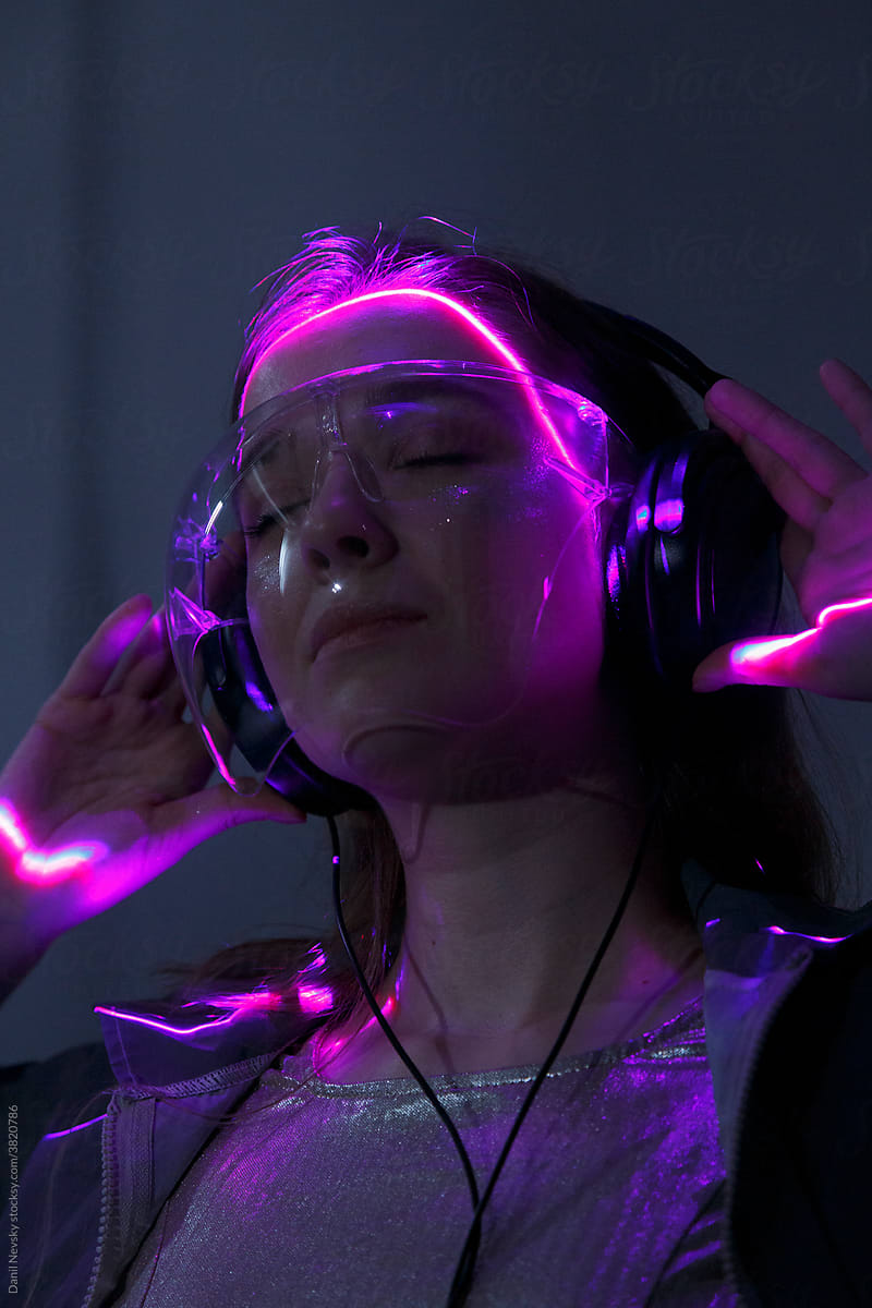 Woman in headphones and googles in neon illumination