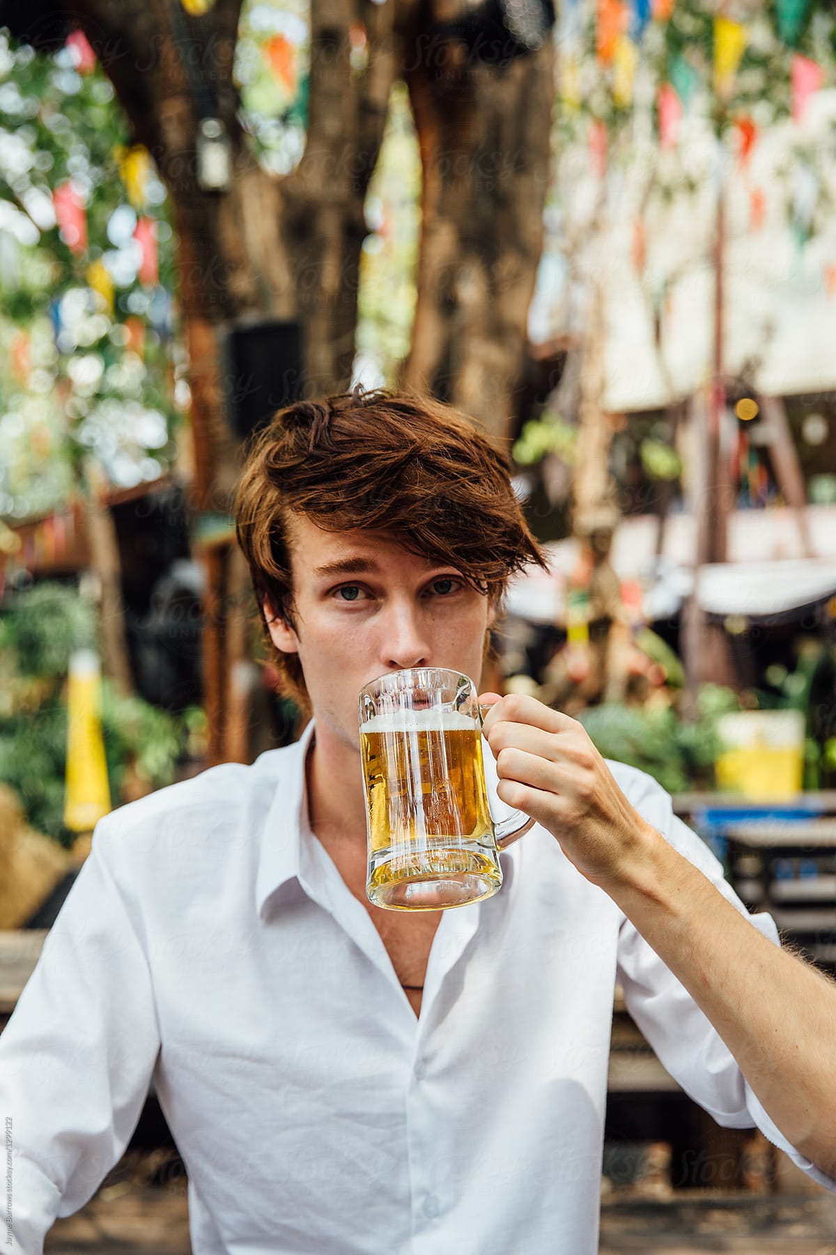 Young Man Drinking Beer by Jayme Burrows - Stocksy United