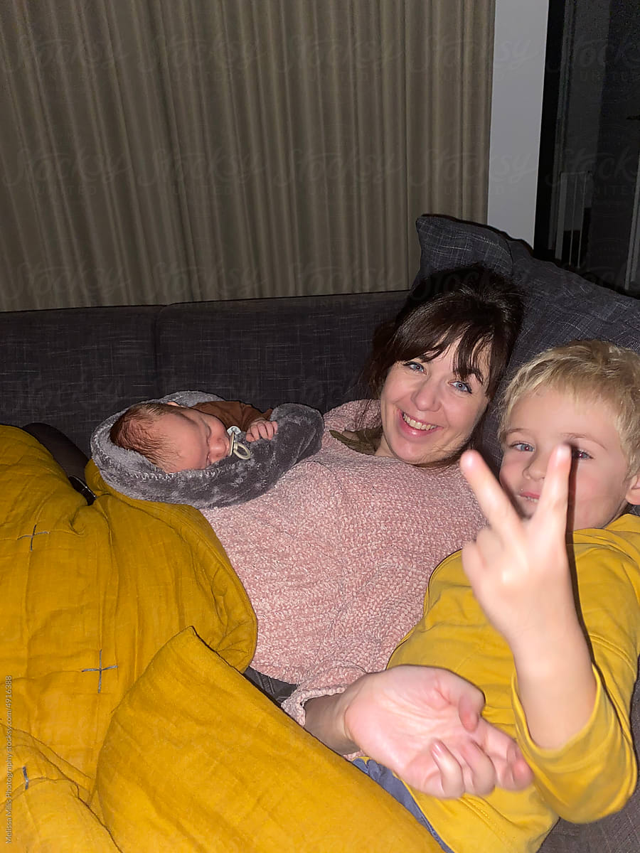 young mother with 2 small children hanging on the couch