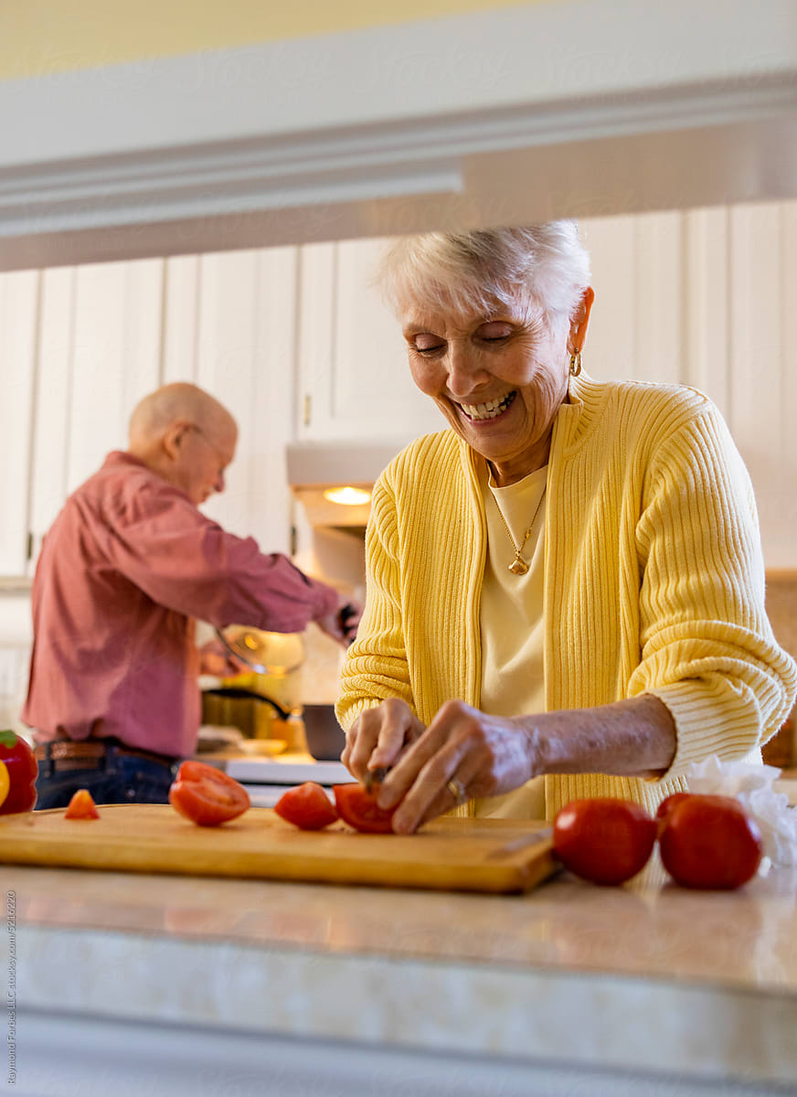 Senior Citizen couple at home cooking healthy dinner together