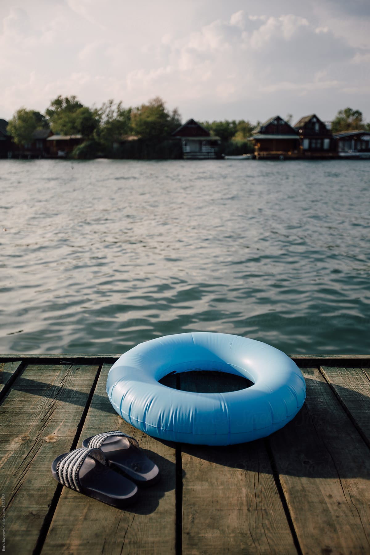 A Blue Swim Ring And Slippers On The Dock