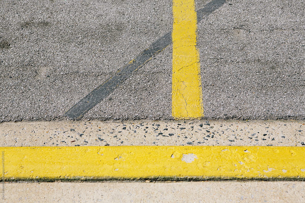 Detail of painted yellow curb and sidewalk