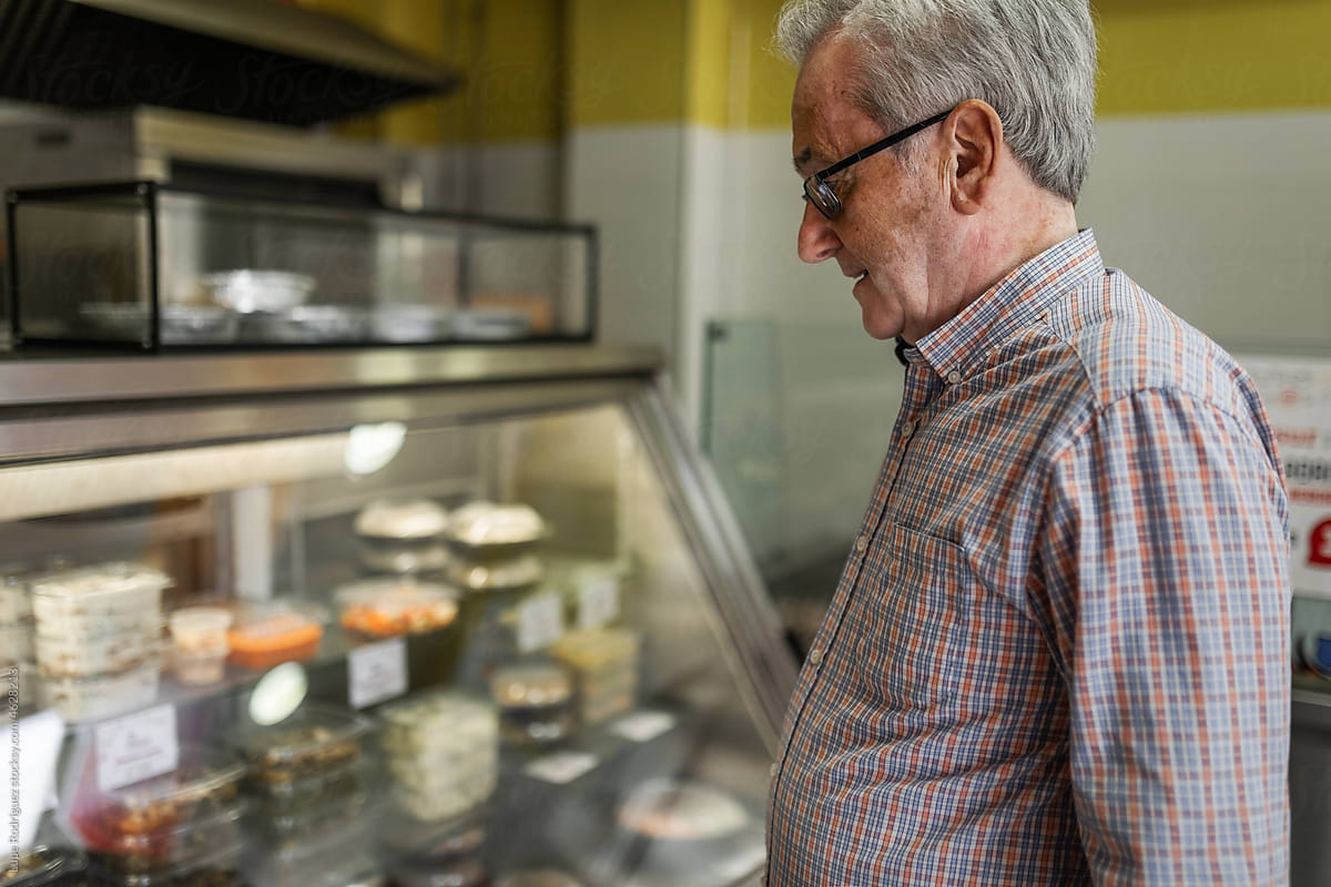 Senior man looking at food products at a store counter