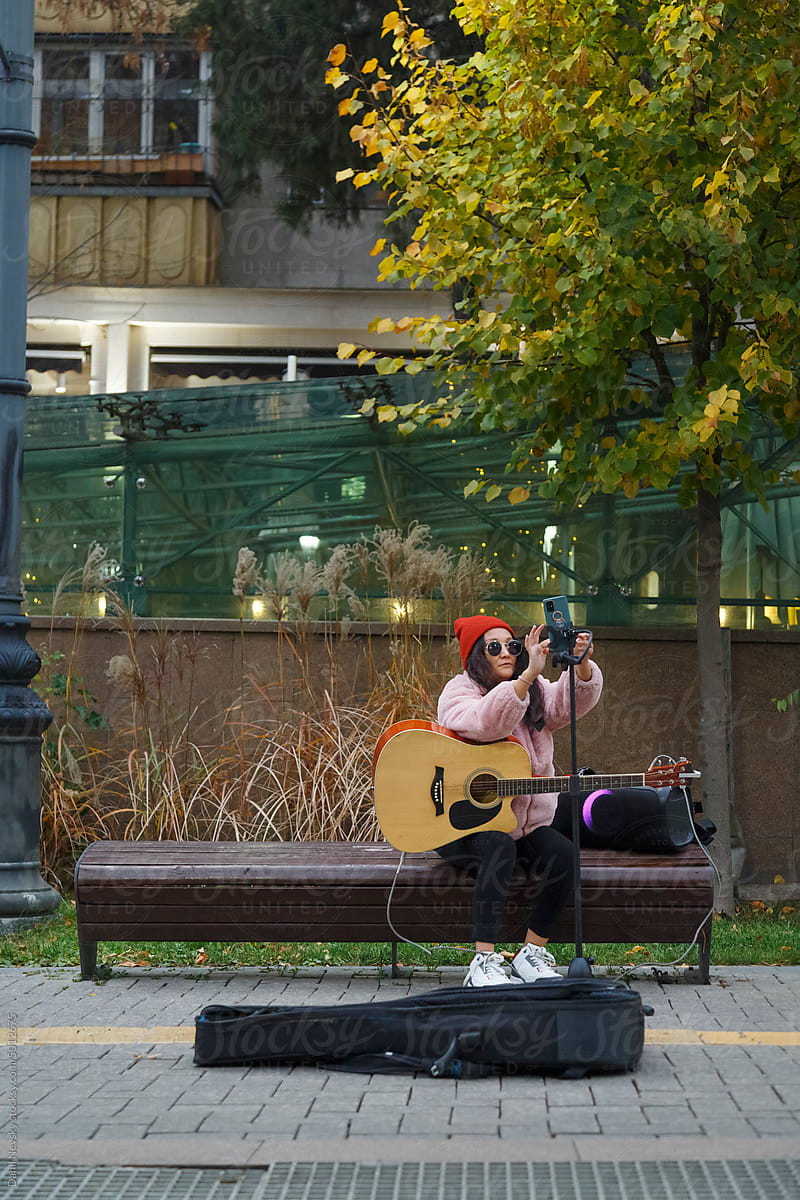 Female vlogger preparing for busking in city park
