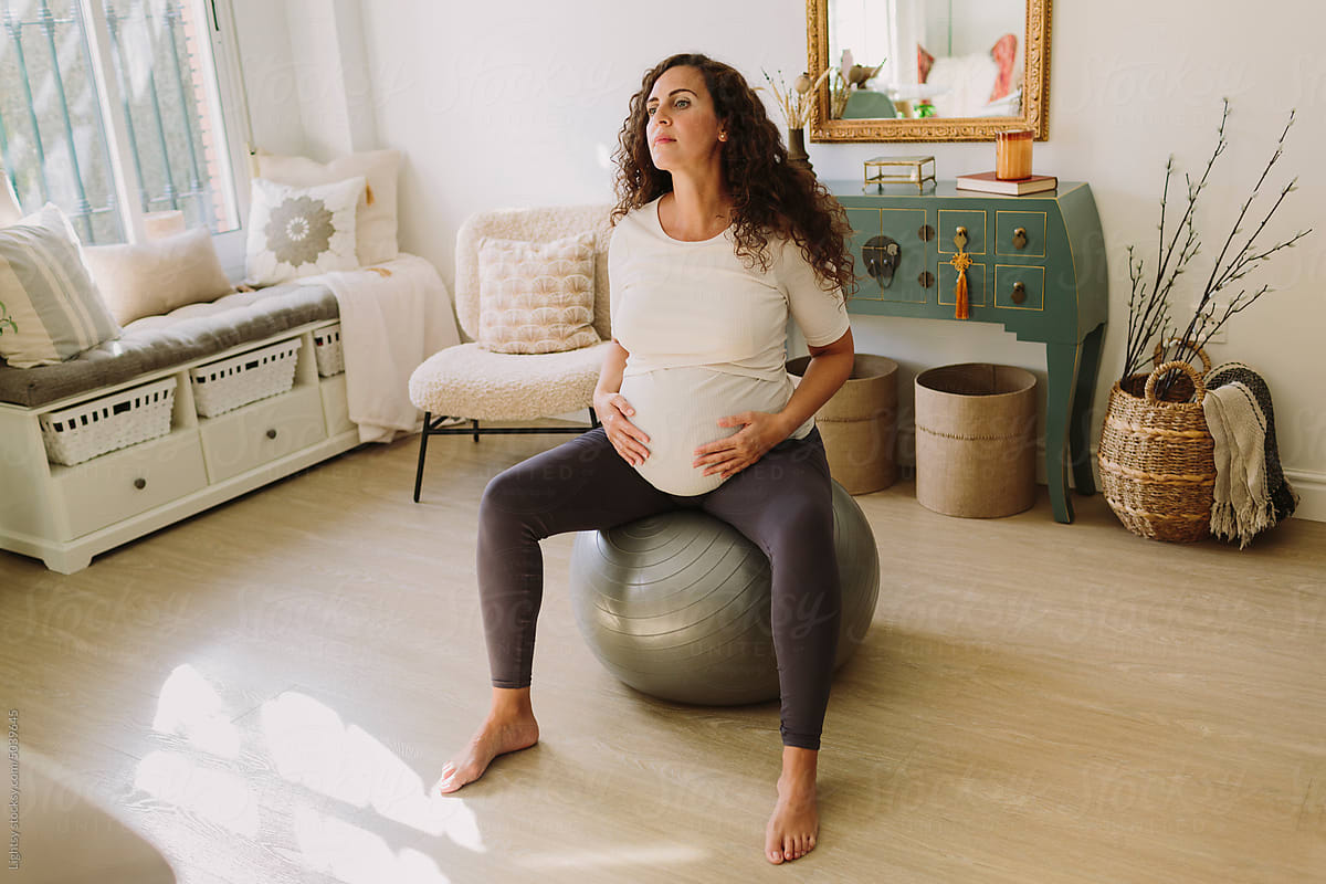 Beautiful pregnant woman sitting on a yoga ball