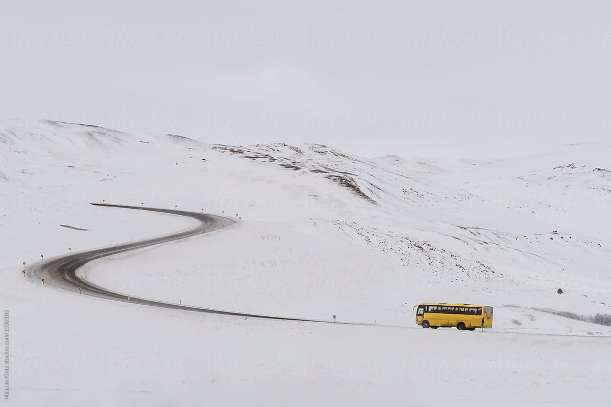 Yellow bus approaches pass in mountains, Northern Iceland
