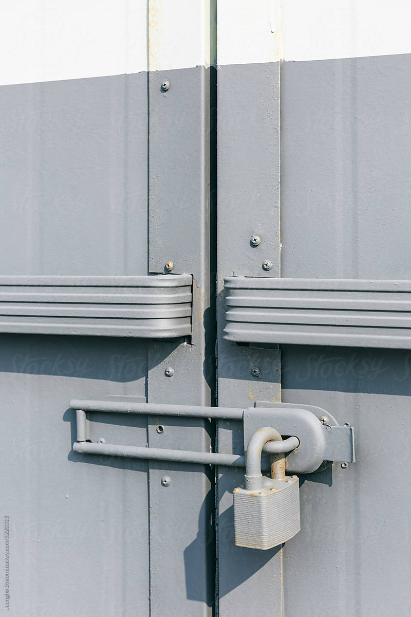 Lock on the door of a gray warehouse building.