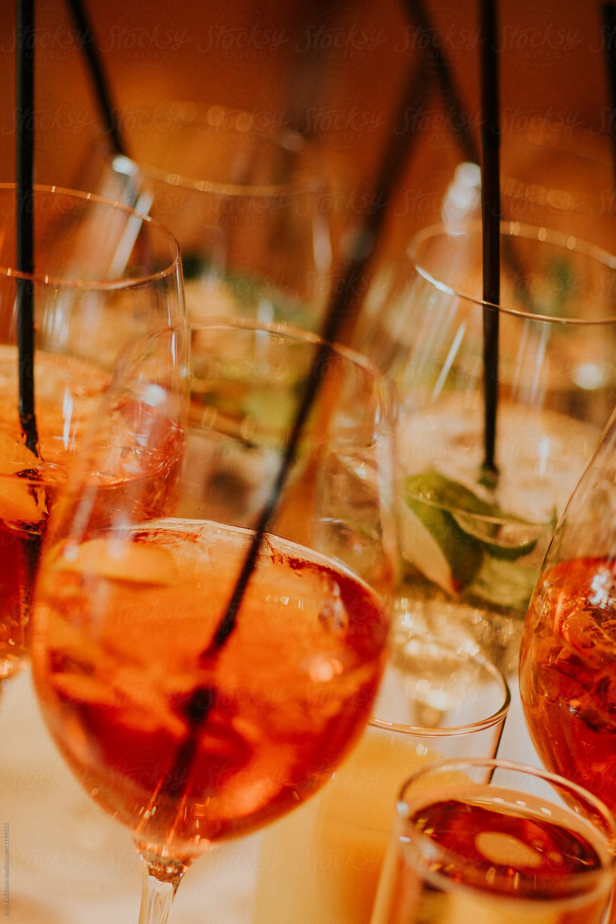 Rows of half full cocktail glasses with straws