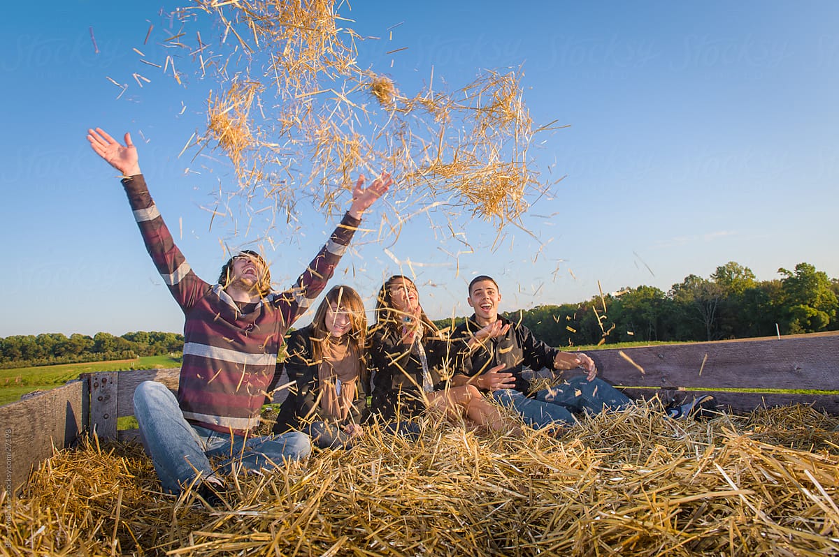 Young adults having fun out doors during an Autumn hay ride.