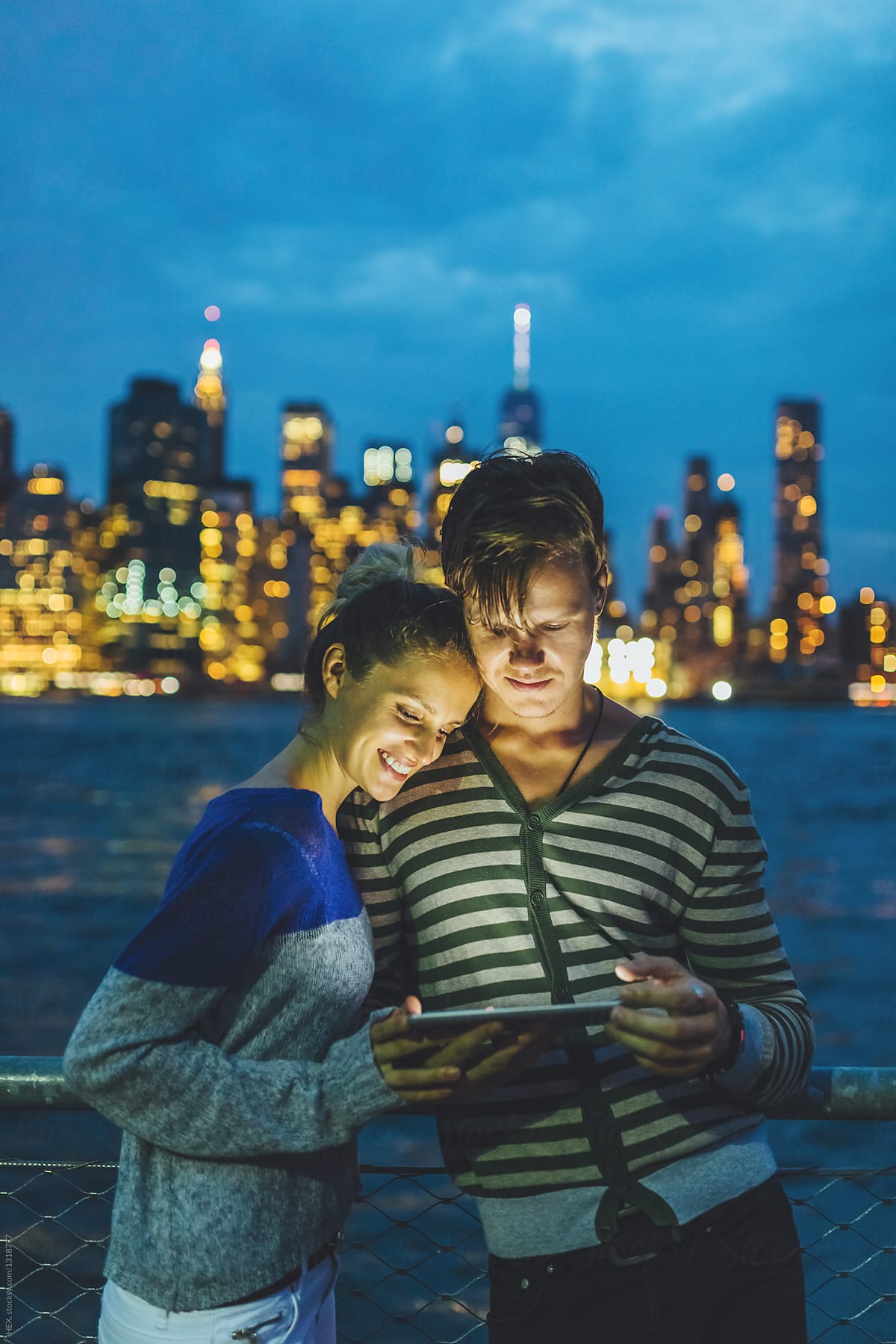 Young Couple Discovering New York City by Night With a Digital Tablet. US