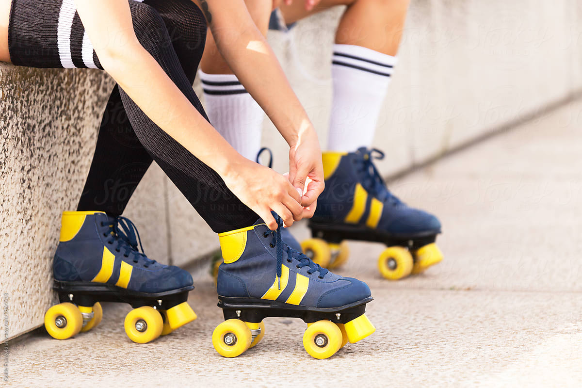 Girl tying rollerblade lace.