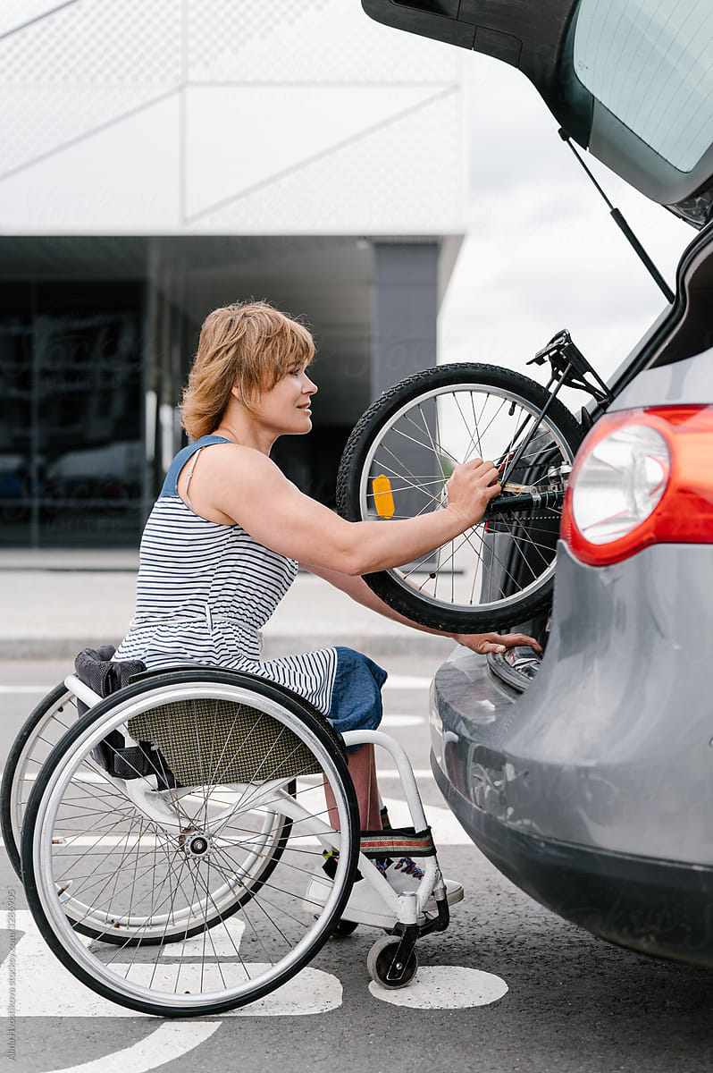 Female with disability putting handbike into trunk