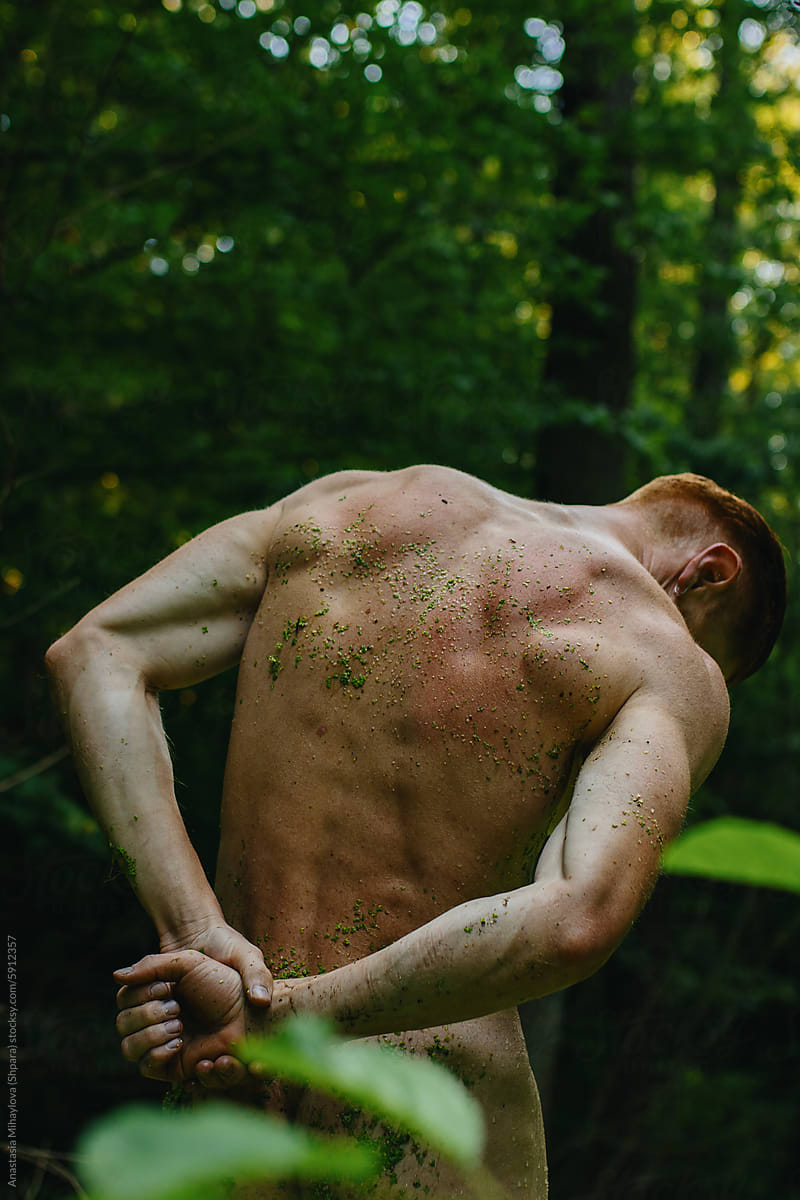 Redhead Man bare-chested athlete in a green swamp outside