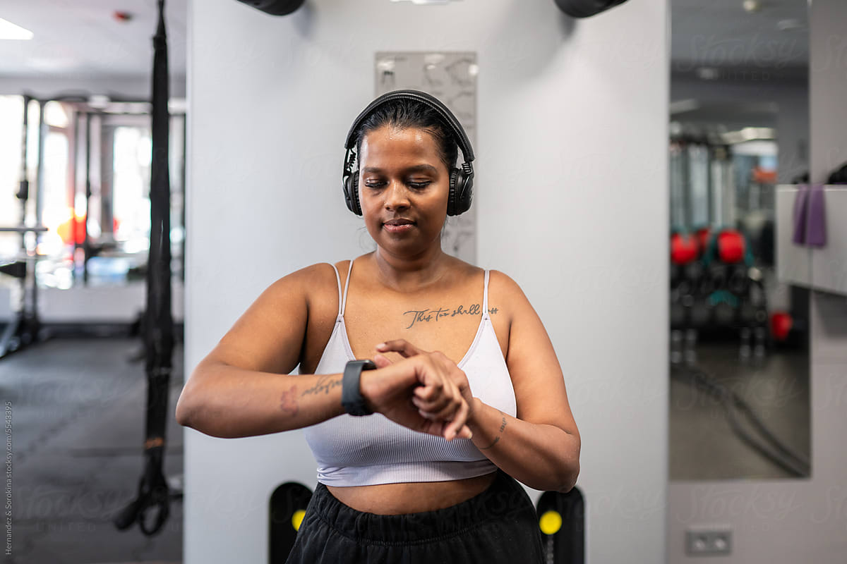 Woman Analyze Progress In The Gym Looking At Her Watch