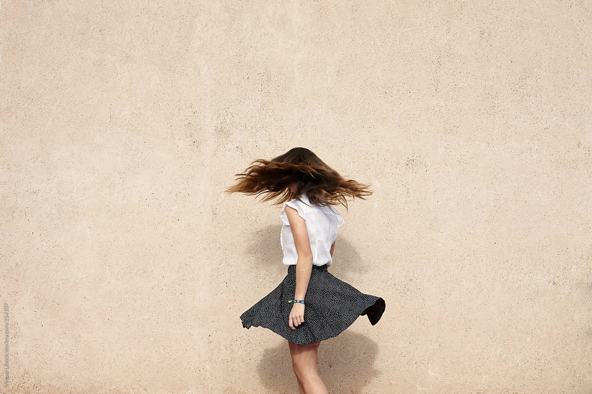 Unrecognizable young woman in turning motion - flying hair and skirt