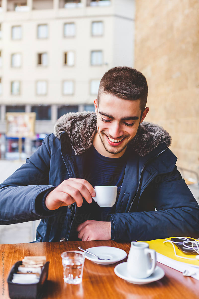 Happy Young Man Having an Italian Espresso during the Cold Season