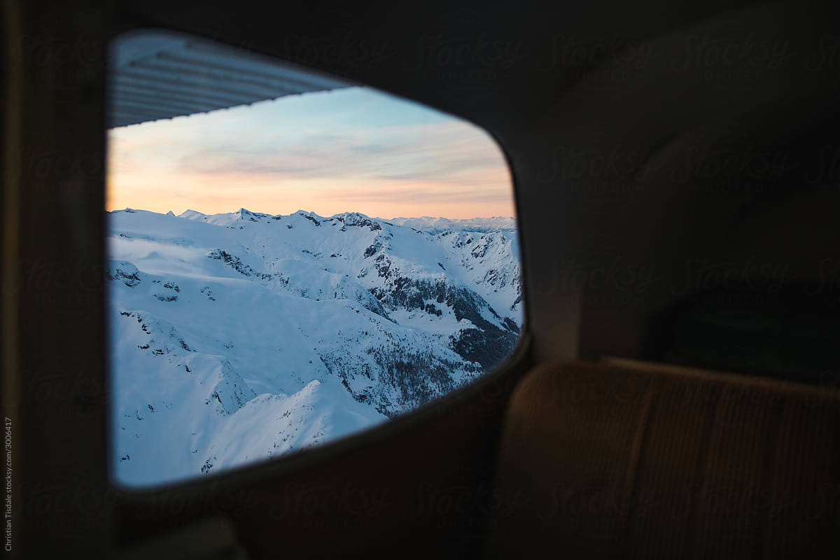 Looking out the back window of a small airplane at the mountains below