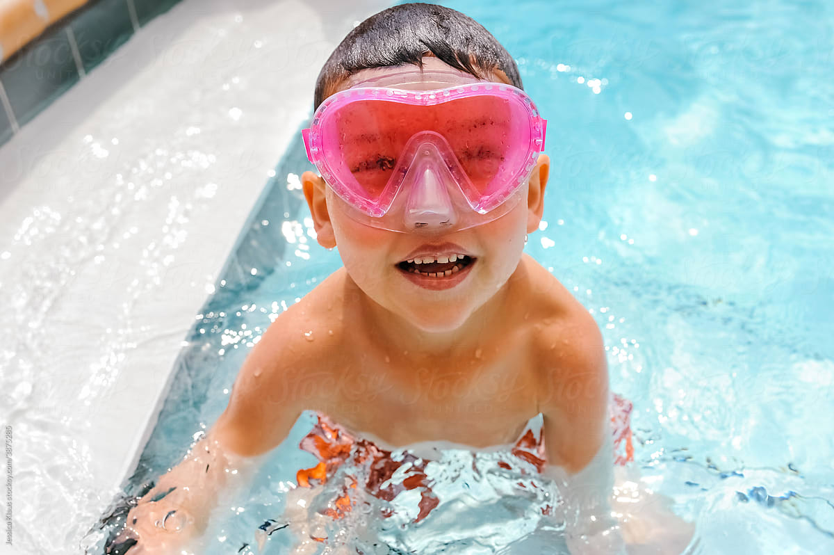 Child wearing pink swimmer goggles.