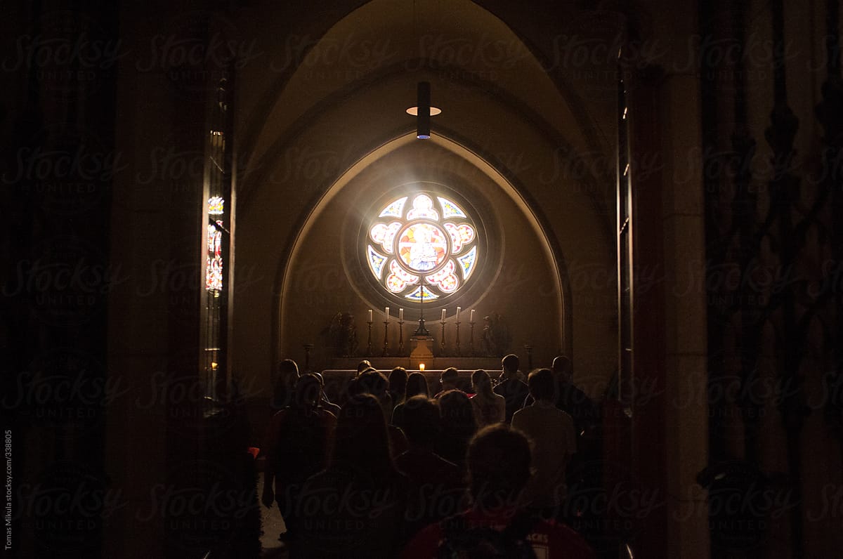 People in front of stained glass in the church