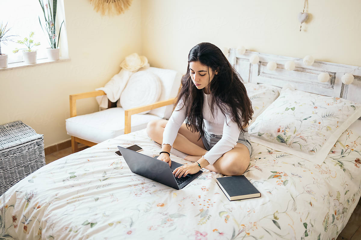 Young Woman Using Laptop In The Bedroom