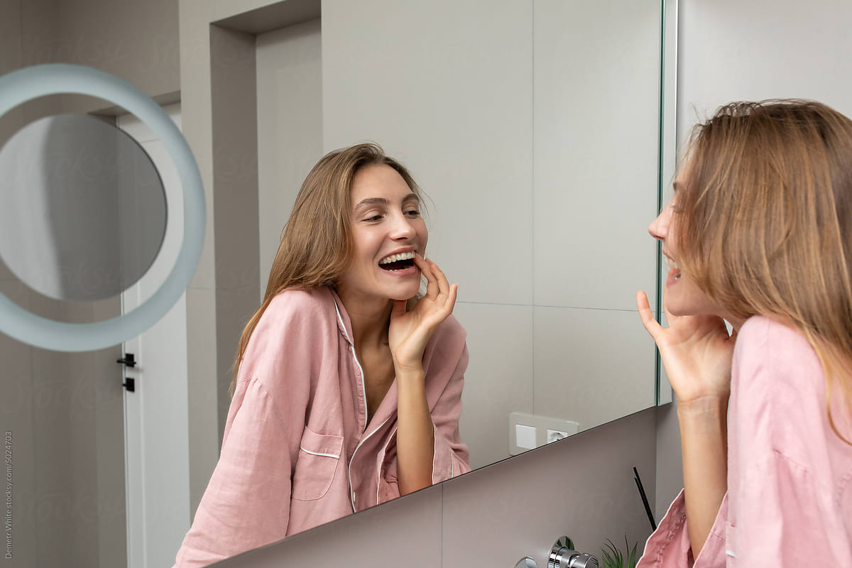 Smiling woman looking into mirror