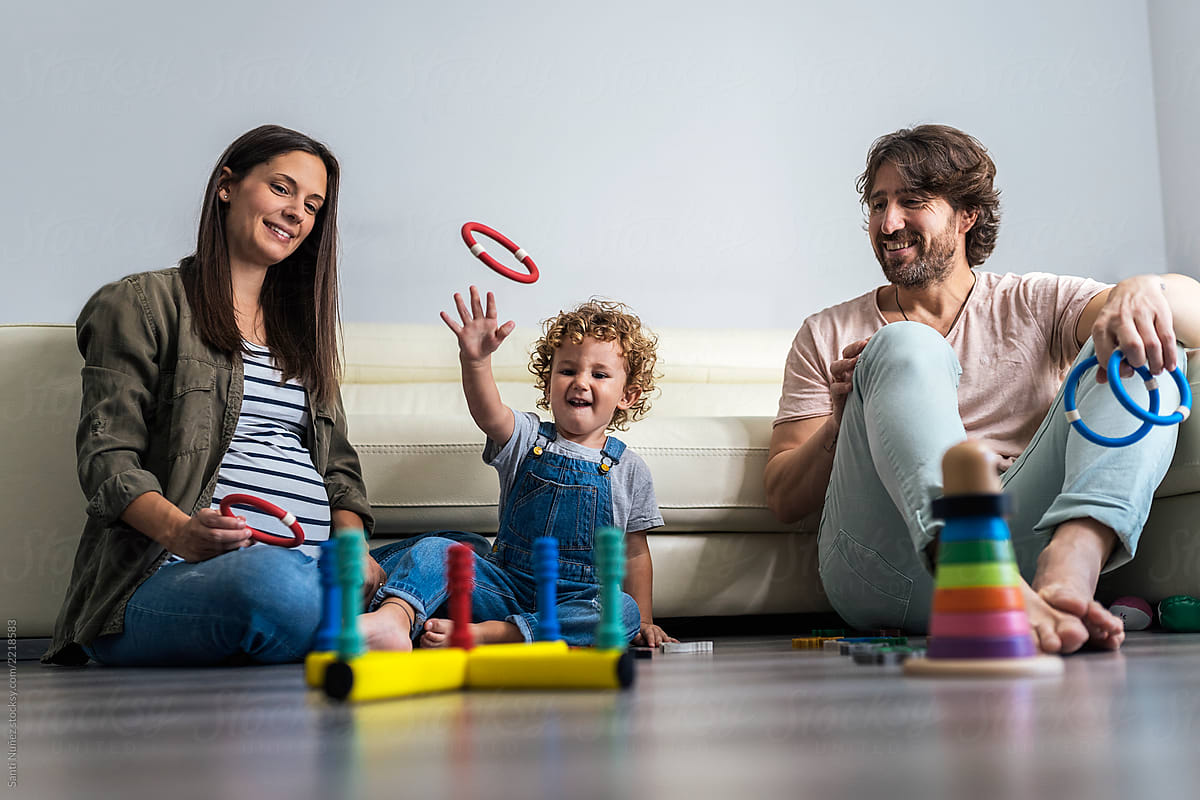 Adorable happy family playing with toys at home