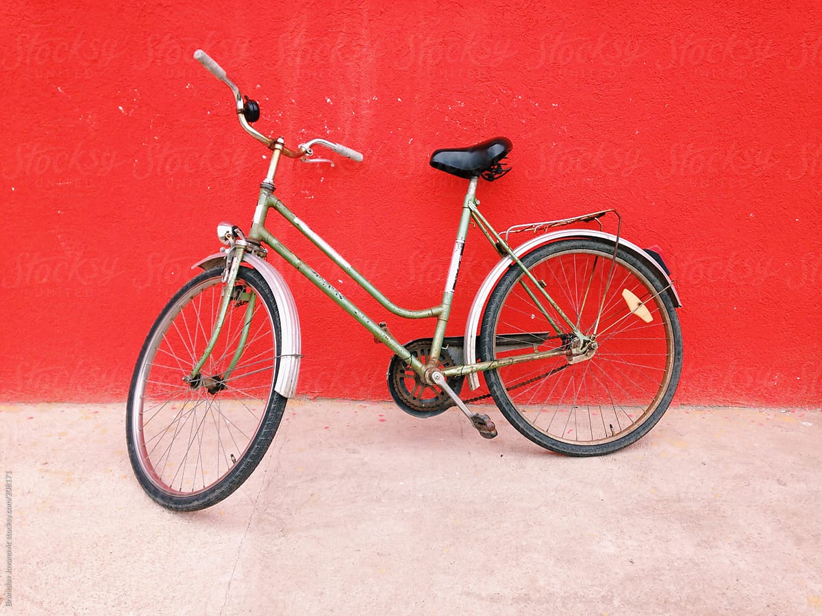 Retro bike leaning on the red wall