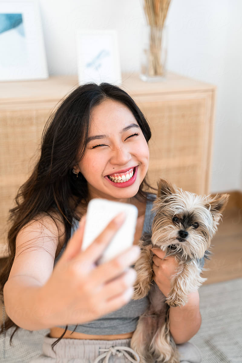Smiling woman taking selfies with her dog.