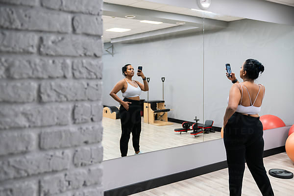 Curvy Woman Doing Selfie In The Gym Mirror by Stocksy Contributor  Hernandez & Sorokina - Stocksy