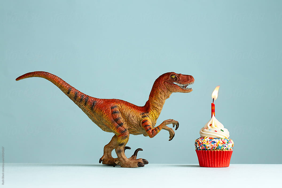 Dinosaur celebrating with a birthday cupcake