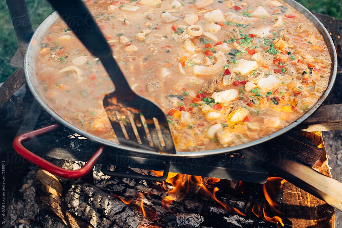 Spanish paella cooking over a fire