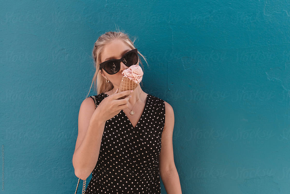 A Beautiful Young Blonde Woman Eating A Pink Ice Cream Cone In The City By Stocksy Contributor