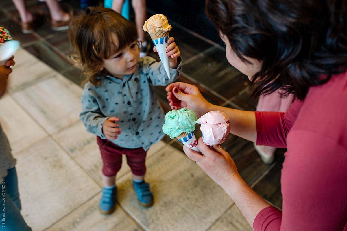 Mother hands young son an ice cream cone