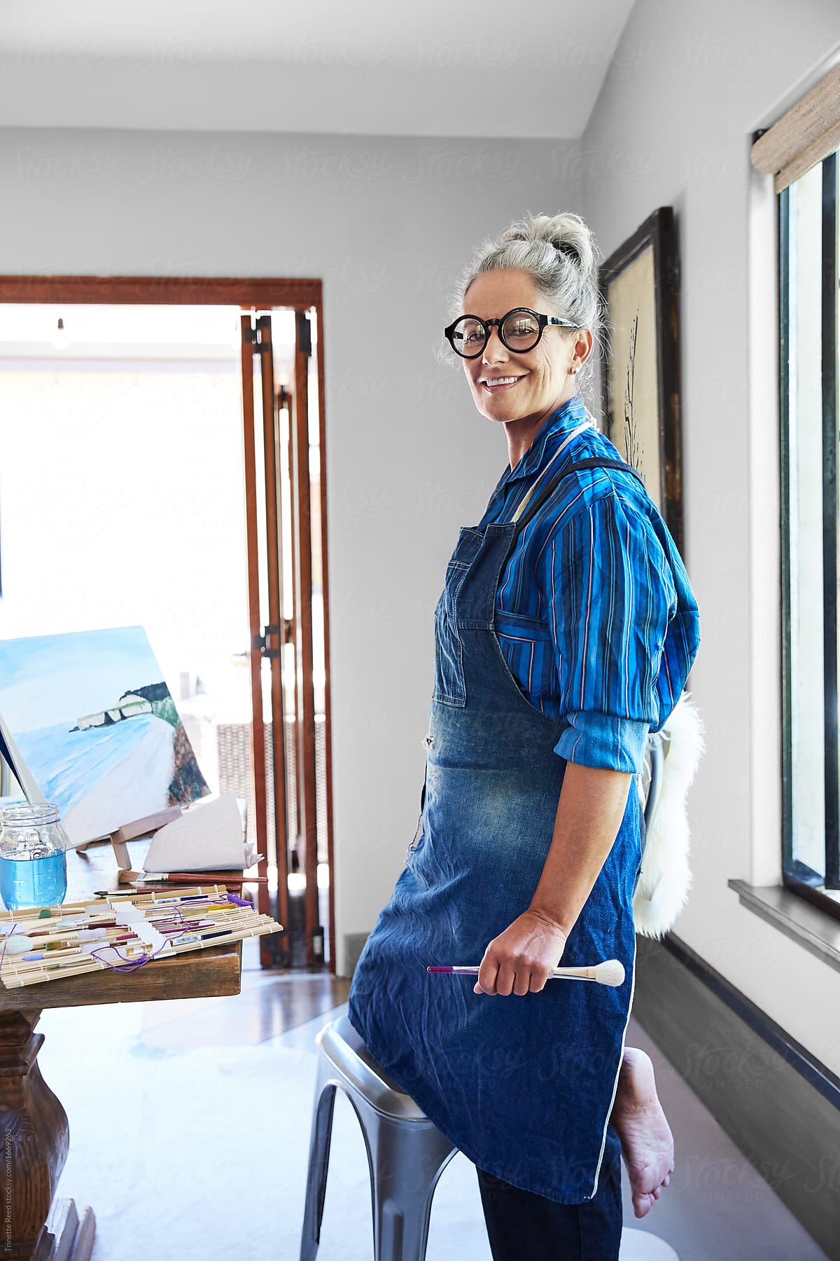 Artist Portrait Of Mature Woman With Grey Hair In Her Art Studio In