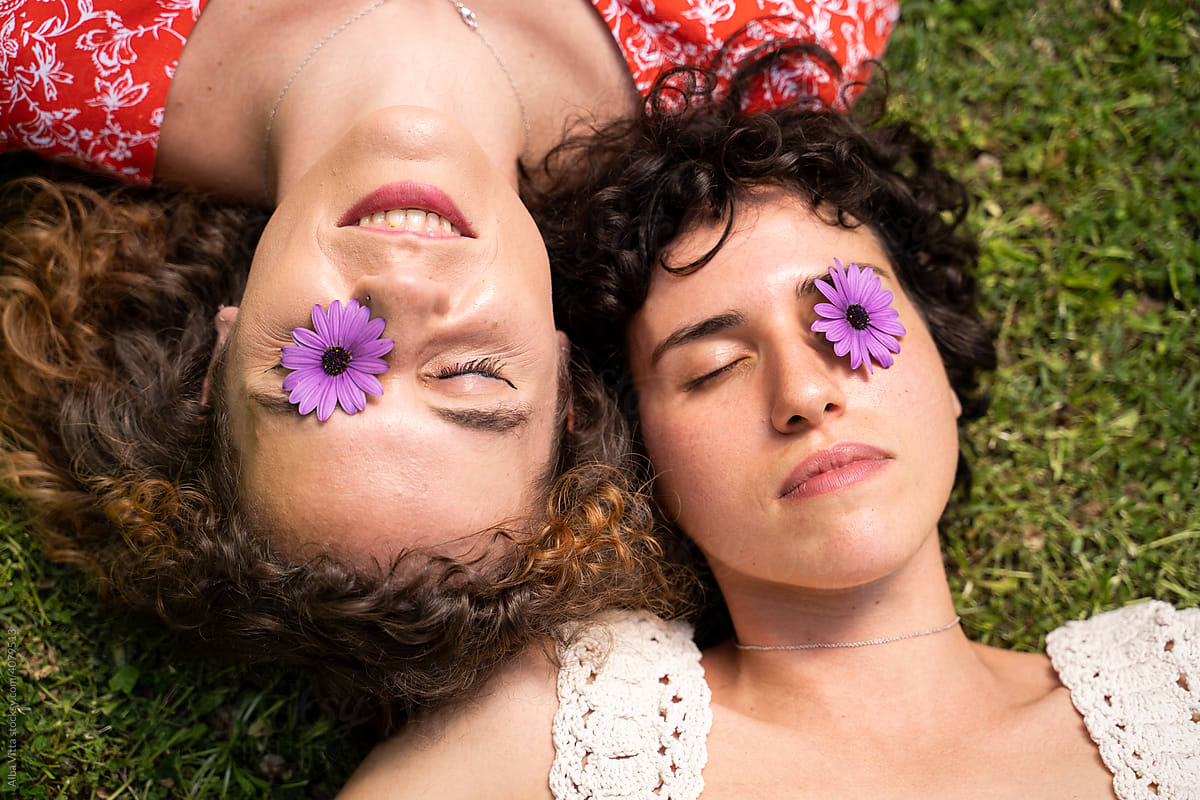 Chill Friends laying on grass covering eyes with flower