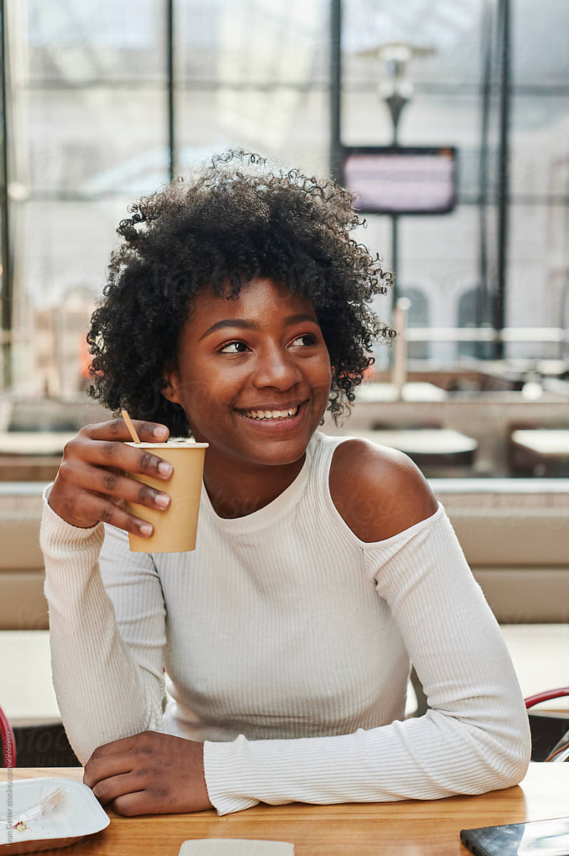 Smiling young woman drinking coffee