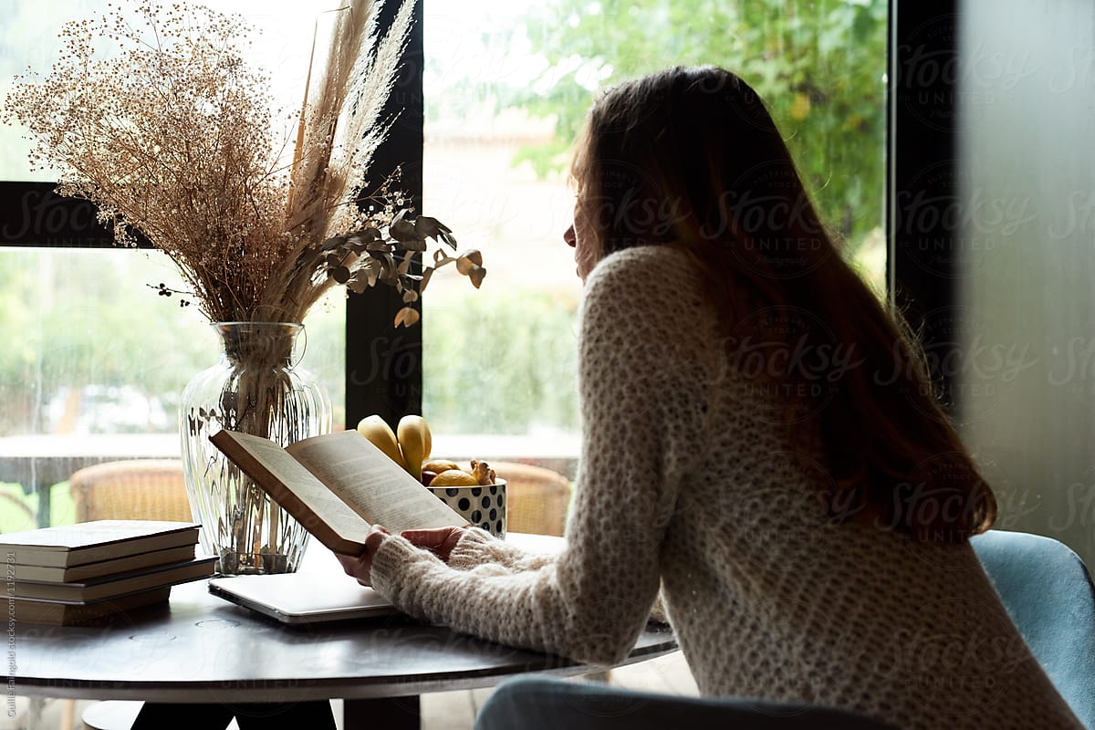Brunette reading book at home