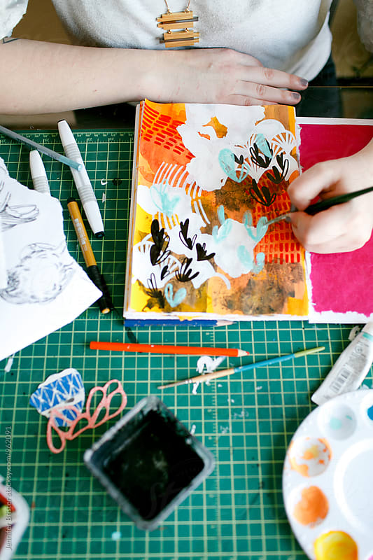 Artist creating colorful art on messy table