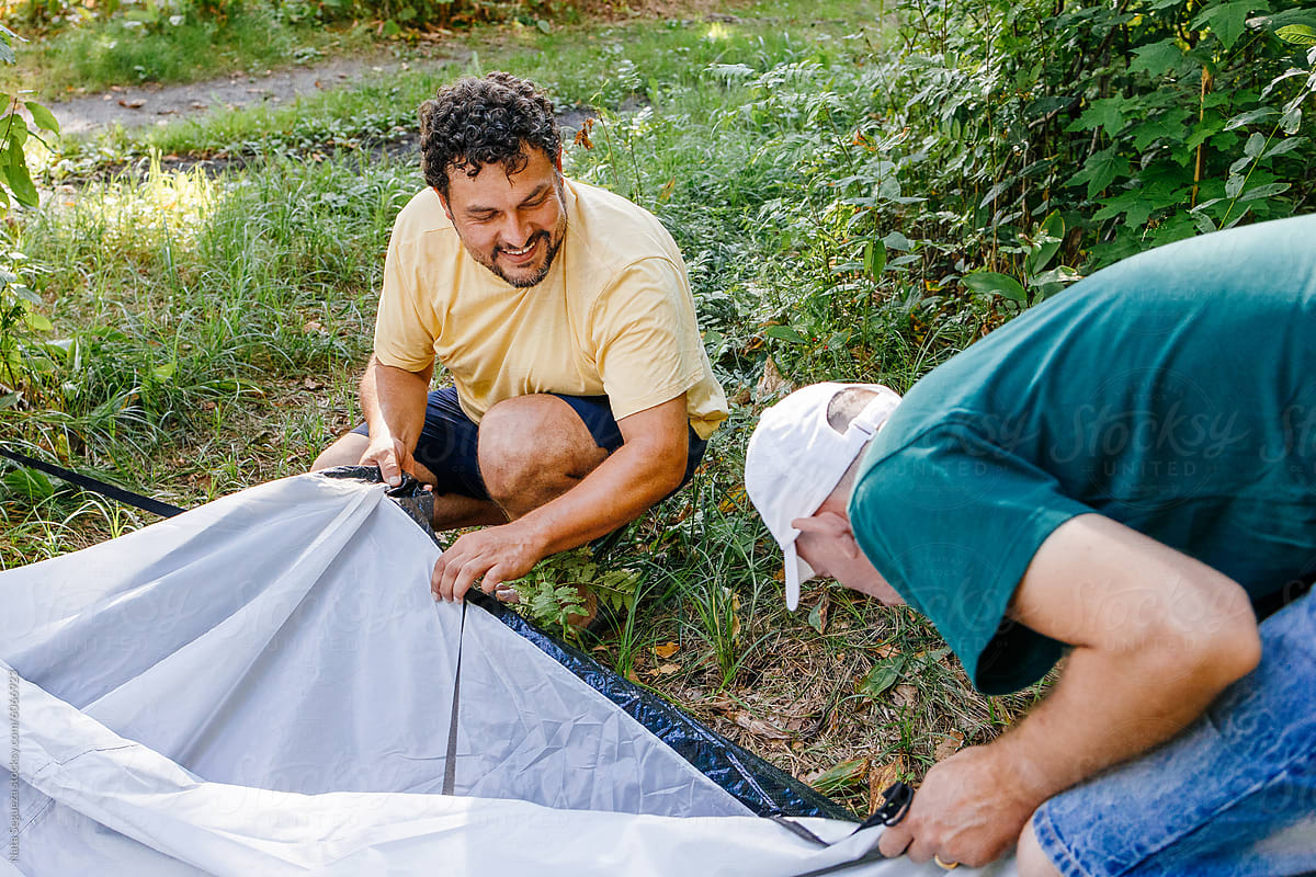 Two Men Setting Up Tent in Forest