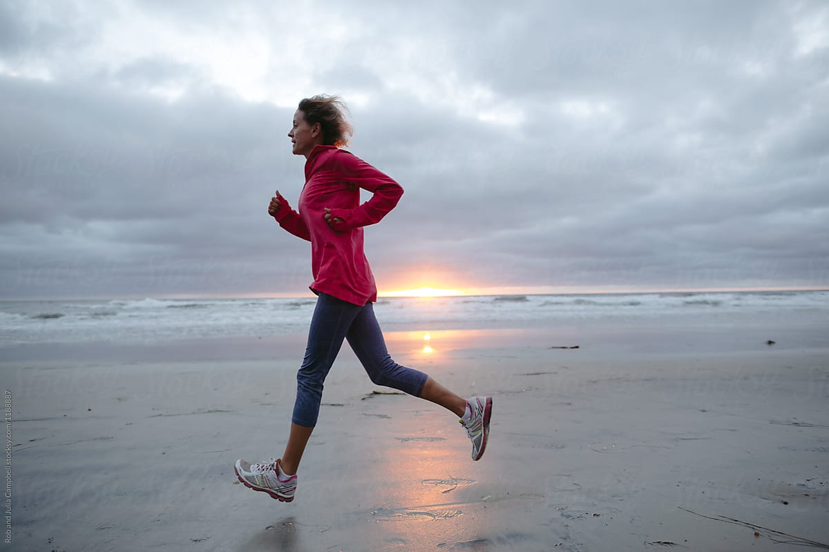 Middle Age Woman Jogging On The Beach At Sunset By Stocksy Contributor Rob And Julia Campbell