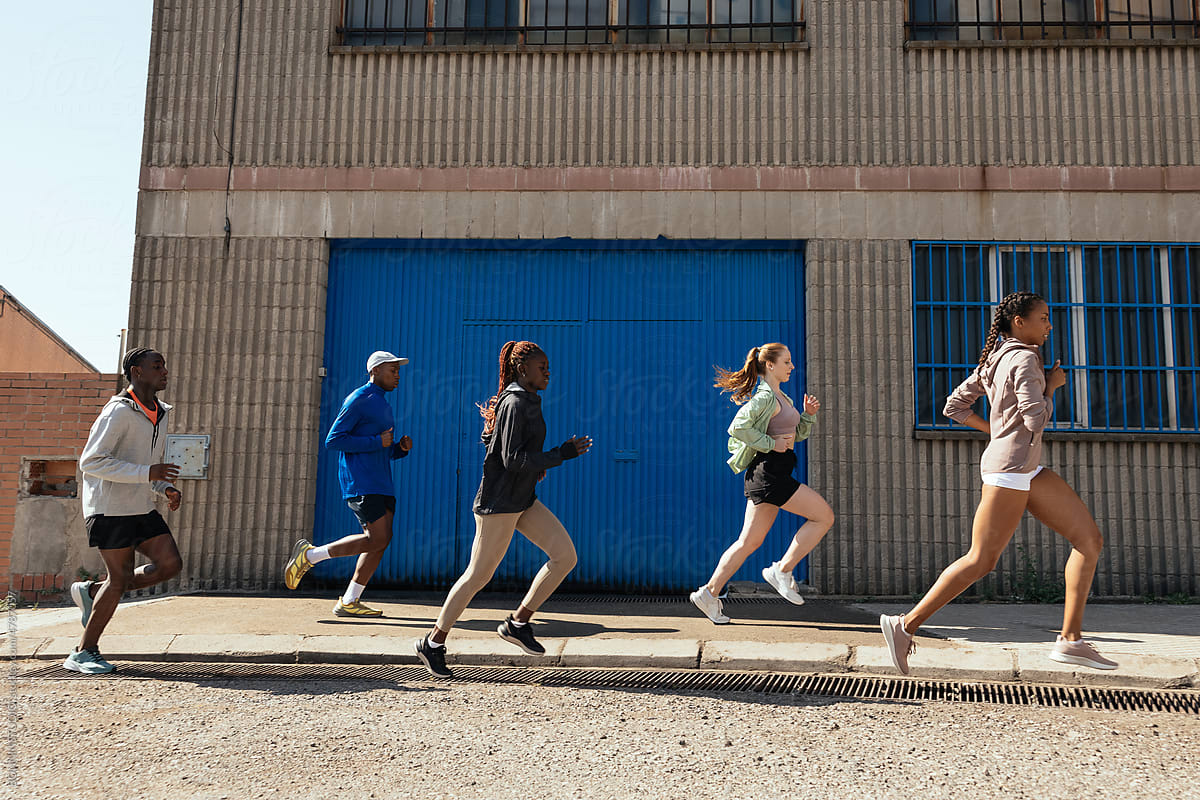 Diverse sportspeople running on street